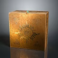 Golden Decorative Box With Intricate Floral Patterns And Green Gemstone On Top