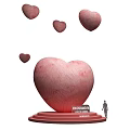 Art Installation Featuring Large Pink Heart Base Unconditional Love Text Floating Small Hearts And Figure