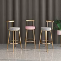 Modern Luxury Bar Stools with Golden Metal Legs and Gray Padded Seats in Contemporary Interior