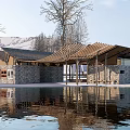 Modern Pavilion With Wooden Roof Stone Walls By Water Reflection Surrounded By Trees Mountain Backdrop
