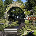 Serene Park Landscape With Stone Arch Lush Trees And Green Vegetation