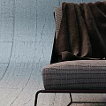 Modern Leisure Chair with Woven Fabric Black Metal Frame and Brown Blanket Against Concrete Wall