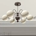 Elegant Chandelier Featuring White Spherical Shades And Dark Brown Balls On Light Wall With Moldings