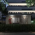 Commercial Street Night View With Lush Green Plants Surrounding Modern Buildings And Warm Lighting