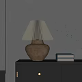 Pleated Beige Table Lamp On Black Cabinet With Stack Of Books