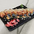 Fresh Sushi Roll with Creamy Sauce Crunchy Toppings and Wasabi Pickled Ginger on Black Plate
