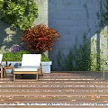 Cozy Courtyard Garden Featuring Wooden Deck White Lounge Chairs And Ivy Covered Stone Wall