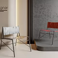 Designer Modern Dining Chairs With Metal Frame And Colored Upholstered Seats In Minimalist Display Setting