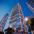 Modern High Rise Residential Building With Glass Curtain Wall And Night Lighting