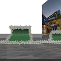 Outdoor Photo Spot With Green Wave Shaped Structure White Flowers And Modern Buildings