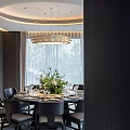 Modern Restaurant Dining Space With Round Table Black Chairs Flower Centerpiece Chandelier And Window View