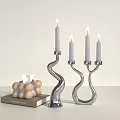 Modern Silver Curved Candle Holders With Lit Candles And Decorative Accessories