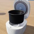 White Kitchen Rice Cooker With Open Lid And Black Inner Pot Measuring Marks