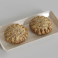 Two Fresh Seed Topped Round Baked Pastries On White Rectangular Tray