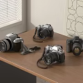 Various Vintage and Modern Cameras with Straps on Wooden Table Top