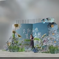 Summer Themed Photo Check In Spot With Blue Backdrop And Floral Decorations