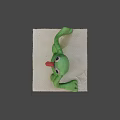 Green Plush Game Movie Character Sitting With Big Eyes Open Mouth And Teeth