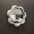 Flower Shaped Mirror on Brown Wall Reflecting Bedroom with Bed Pillows and Copper Pendant Light
