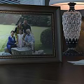 Classic Photo Frame With Family Photo On Wooden Tabletop And Crystal Lamp