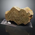 Wooden Stone Exhibiting Wavy Layered Texture in Brown Yellow Color on Display Mat