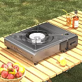 Portable Gas Stove For Outdoor Cooking On Wooden Table With Fresh Fruits And Beverages