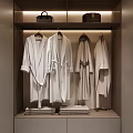 White Robes Hanging In Modern Wardrobe With Folded Towels And Storage Shelves