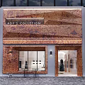 Elegant Lady's Collection Storefront With Textured Brown Facade Glass Display Windows And Warm Lighting