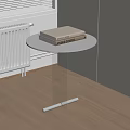 Modern Round Side Table With Black Top And Transparent Glass Stand Holding Two Books