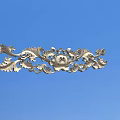 Ornate Metallic Carving With Intricate Curved Patterns And Floral Elements On Blue Background