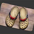 Beige Rubber Clogs With Red Straps Blue Buckles And Perforated Design On Wooden Platform