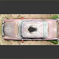 Old Red Rusty Car Model With Body Hole On Grass And Dirt Covered Base