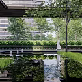 Modern Residential Landscape With Covered Entrance Tall Trees Green Plants And Bench Seating