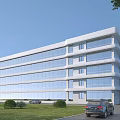 Modern Multi Storey Office Building With Large Glass Windows Surrounding Lawn And Parked Cars