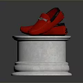 Red Loafers with Metallic Accents Displayed on White Pedestal with Wooden Top