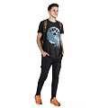 Man in black T-shirt with blue graphic wearing backpack black pants and orange shoes on gray background