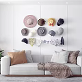 Various Stylish Hats Hanging On Wall In Modern Living Room With Sofa Pillows And Plants