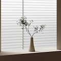 White Ceramic Vase Holding Green Leafy Twigs On Windowsill With White Blinds And Soft Light