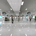 Modern Spacious Bright Station Hall With Multiple Screens And Pedestrians Walking