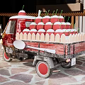 Mobile Gelato Vending Tricycle With Red Topped Ice Cream Cones And Wooden Spoons