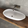 White and Black Washbasin On Wooden Countertop With Gray Tiled Wall And Silver Faucet