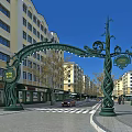 Ornate Green Archway Commercial Street With Yellow White Buildings Shops Pedestrians And Cars