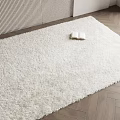 White Square Shaggy Rug on Herringbone Wooden Floor with Open Book and Vertical Striped Wall