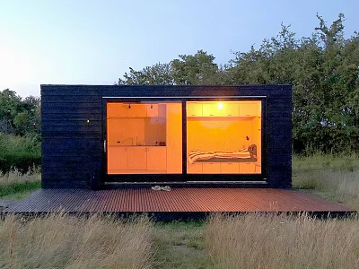 Black Detached House With Large Glass Windows And Lit Interior In Natural Surroundings 3d model