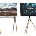 Two TVs on Wooden Tripod Stands Showing Snowy Mountain and Sony 8K HDR Screens