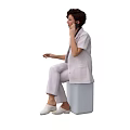 A Woman in White Uniform Sitting on Gray Box Talking on Phone with White Shoes
