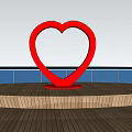 Red Heart shaped Landscape Sculpture On Seaside Wooden Platform With Person And Ocean View