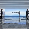 Modern Exhibition Hall With Large Screen Polished Floor Ceiling Light Strips And Visitors