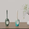 Modern Toilet Brushes With Green And Teal Handles On Wooden Floor Near Plant