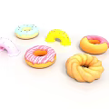 Colorful Frosted Donuts With Sprinkles And Assorted Shapes On White Surface