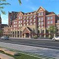 Commercial Street With Red Brick Buildings Clock Tower Multi Story Structures Parked Cars And Green Trees
